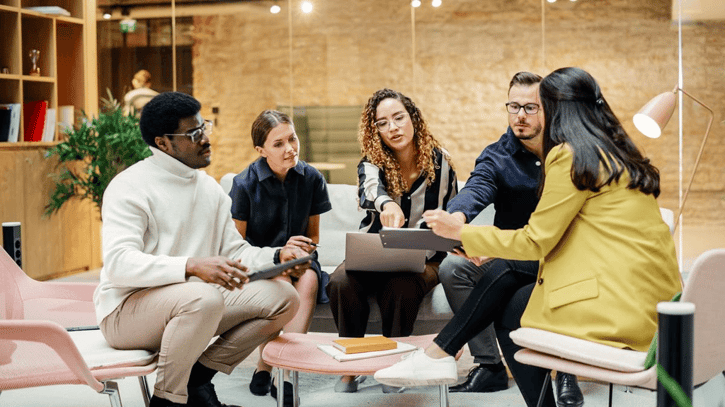 Büroteam diskutiert Feedbackkultur während eines Meetings. 