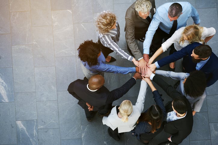 Diverse Mitarbeitergruppe, die sich erfolgreich am Arbeitsplatz ergänzt.