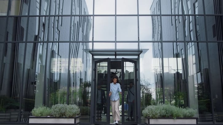 emplaedo molesto saliendo de la puerta de un edificio por despido involuntario