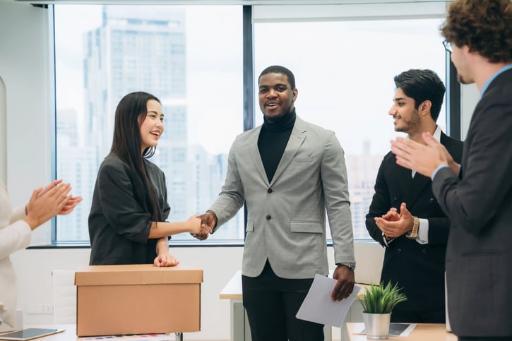 A cheerful young businessman introduces a new female employee, and everyone in the company, symbolizing culture add