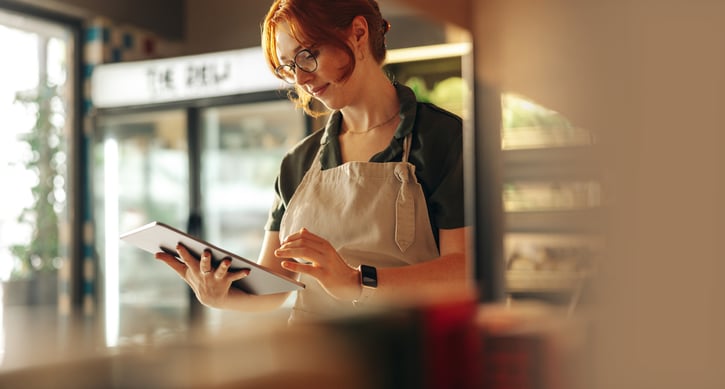 A retail shop owner creating a work schedule on her tablet.