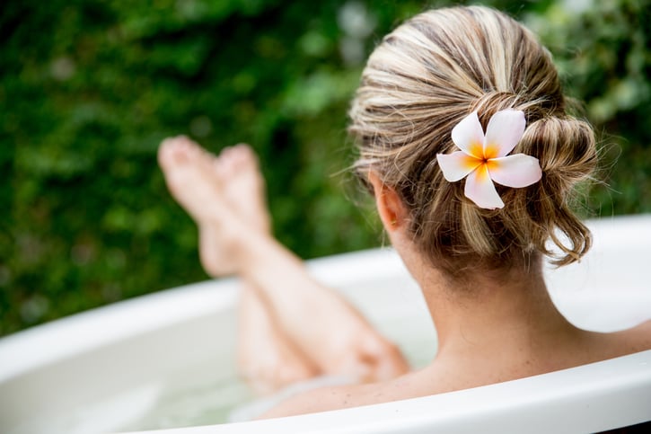 Jeune femme assise dans son bain, profitant de ses congés.