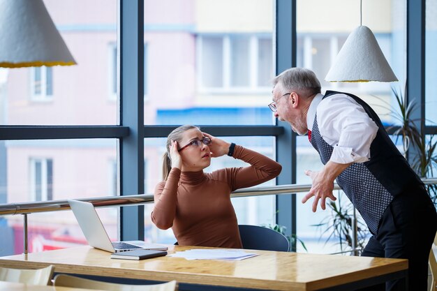 Im Arbeitsalltag treten Mobbingattacken auf, wenn der Chef Bossing gegenüber Mitarbeitern am Schreibtisch ausübt