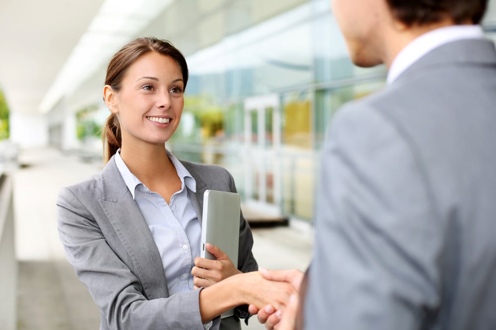 Businesswoman shaking hand to partner