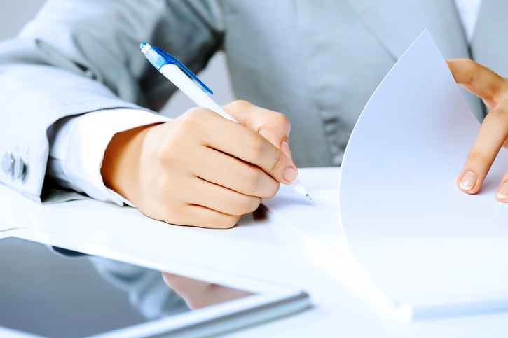  manos de empresaria firmando documentos de un contrato fijo discontinuo
