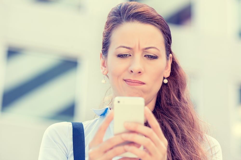 Closeup side profile portrait upset sad skeptical unhappy serious woman talking texting on phone displeased with conversation isolated city background. Negative human emotion face expression feeling-1