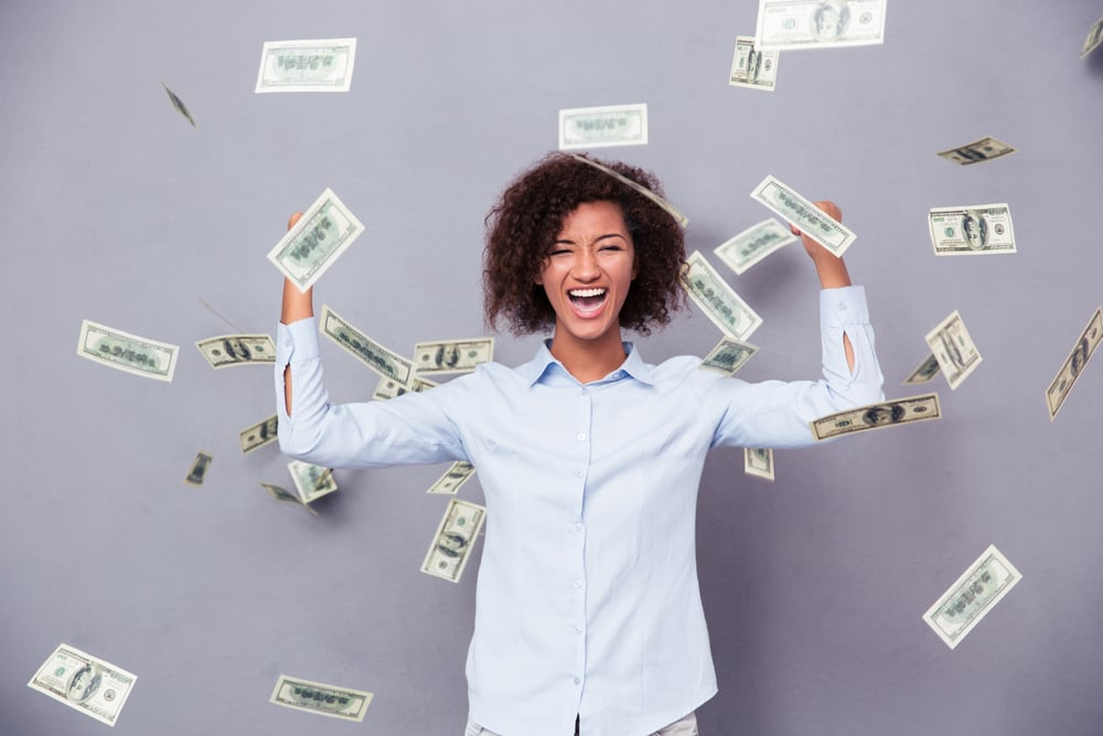 Concept photo of a cheerful afro american woman standing under rain with money on gray background-1