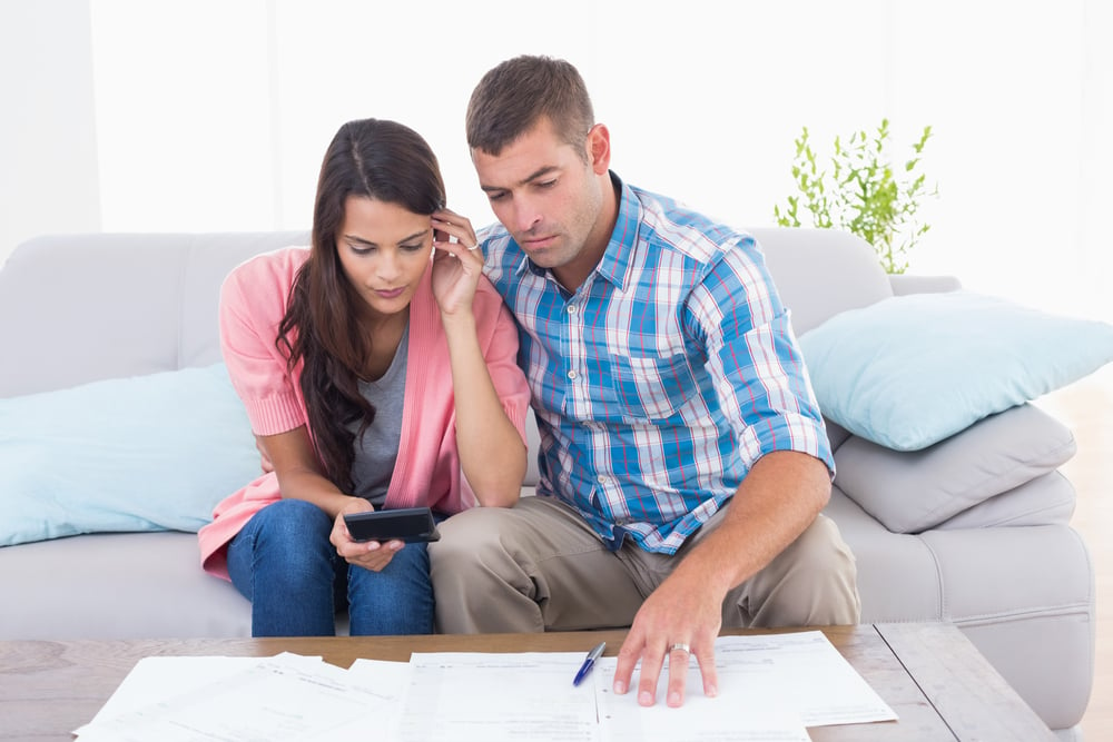 Couple calculating home finances together at table in house
