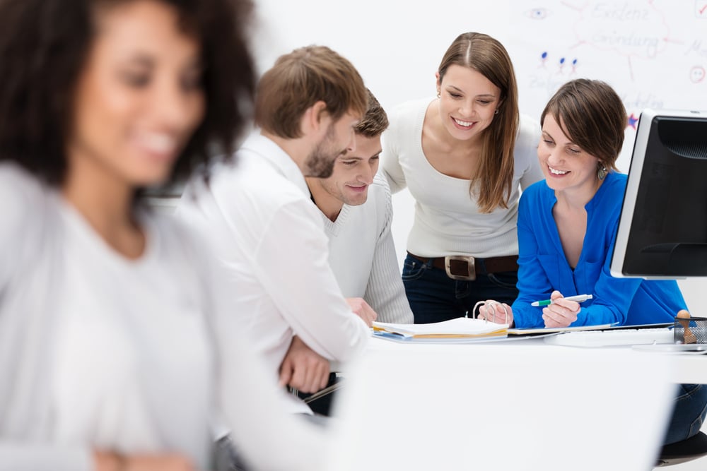 Diverse multiethnic group of young businesspeople in a meeting sitting at a table in the office discussing their business strategy and sharing information-1