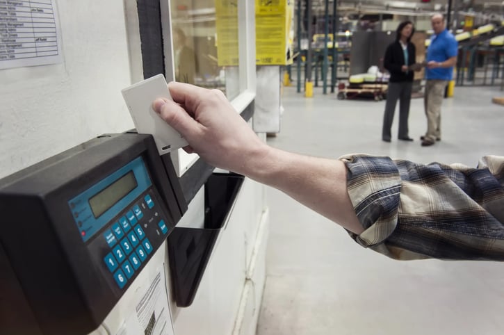 Employee clocking in or clocking out at a factory, using the time clock card