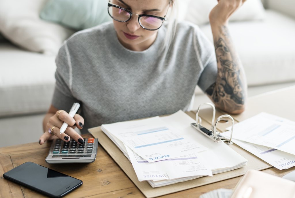 Female employee making calculations while working from home