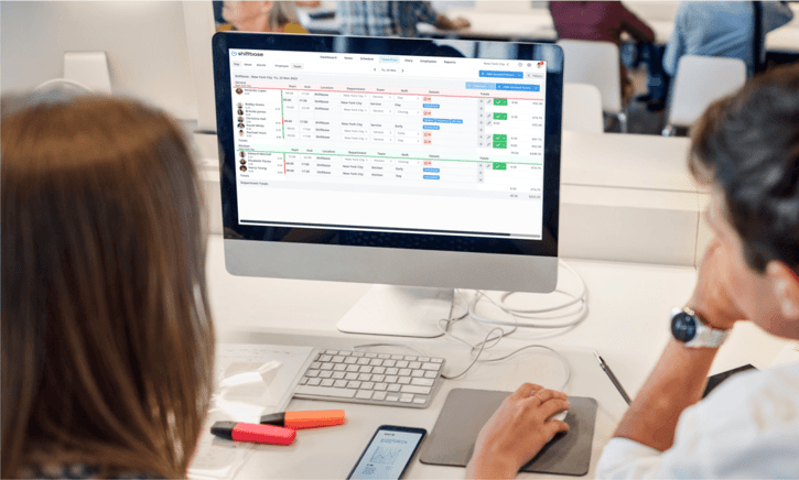 Employees looking at computer screen, creating employee schedule on Shiftbase scheduling tool