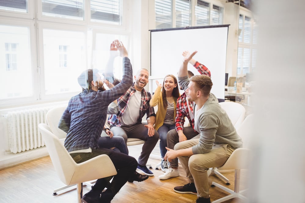 Glückliche Mitarbeiter bei einer Teambesprechung