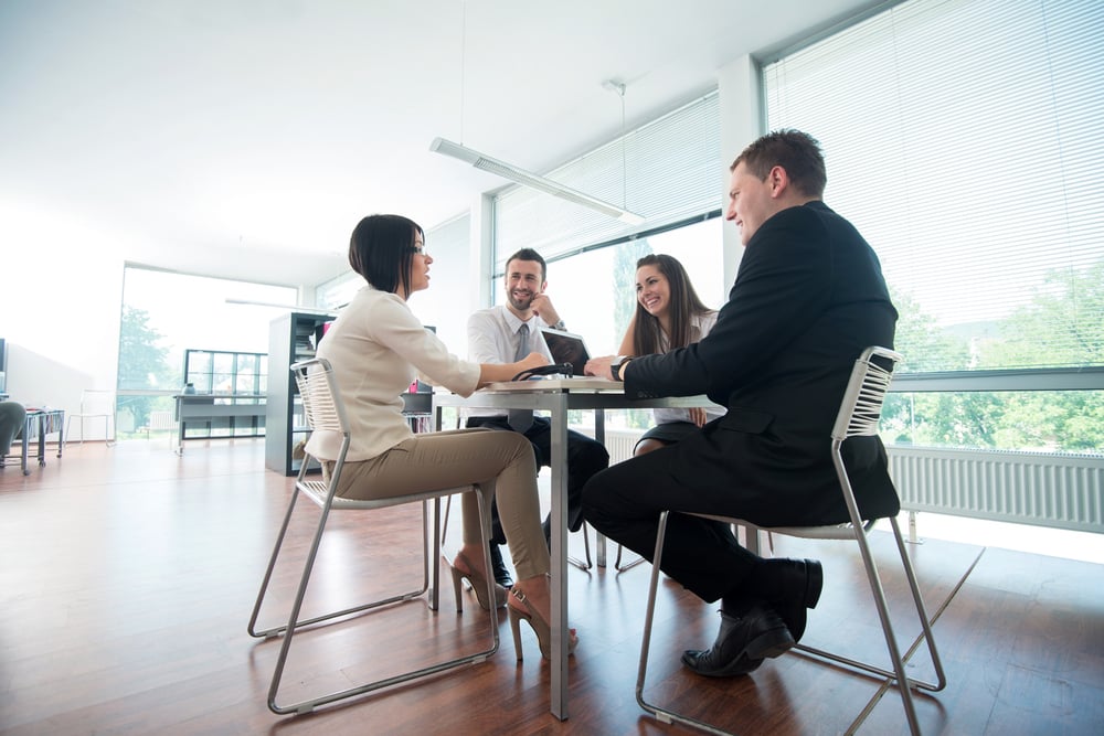 Four business people sitting around office table