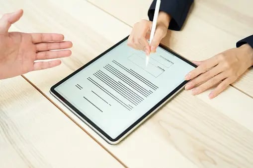 Frau, die ein Dokument mit elektronischer Signatur unterzeichnet.