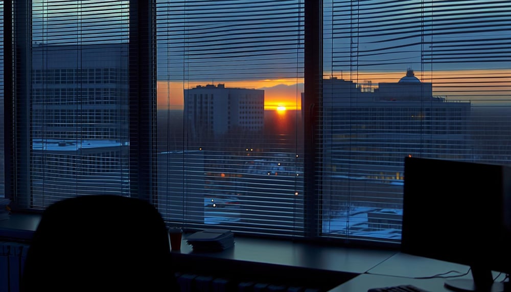 Sonnenaufgang hinter dem Bürofenster während der Frühschicht