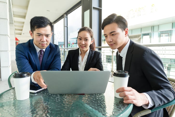 Group of business people discuss about the data showing on laptop computer
