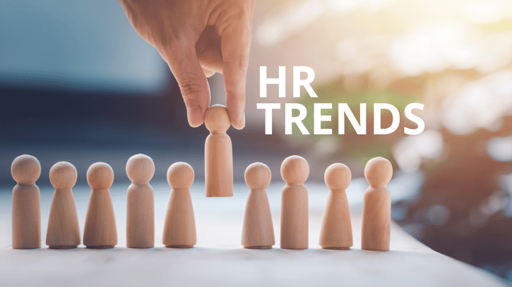 HR Employer picking up wooden doll with HR trends written on the side