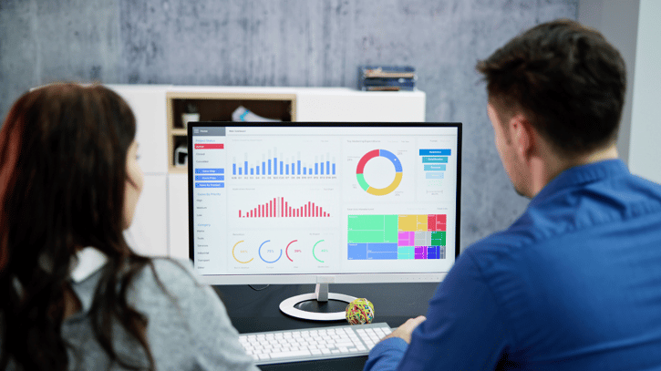 HR employees looking at data on HR dashboard