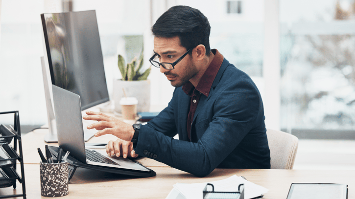 HR manager reviewing payroll reconciliation report on laptop in an office setting