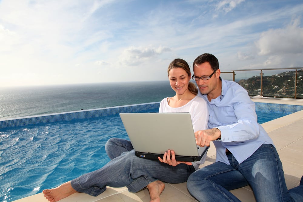 Frau und Mann arbeiten entspannt im Pool während ihrer Workation