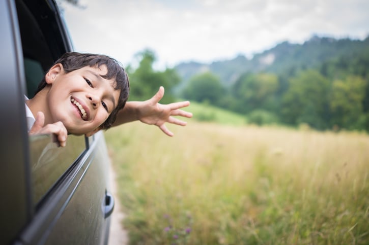 un garçon dans la voiture qui profite de ses vacances
