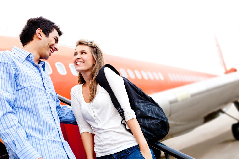 Happy loving couple traveling by airplane and smiling