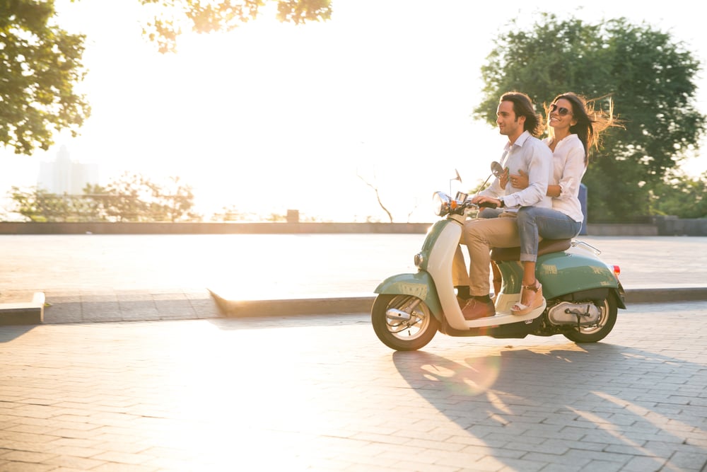 Un homme et une femme sur un scooter profitant d'une balade en ville