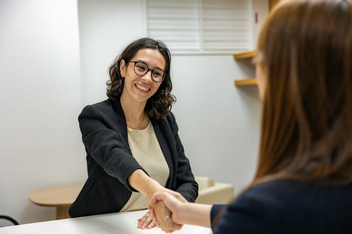 Werkgever schudt de hand van een werknemer in loondienst