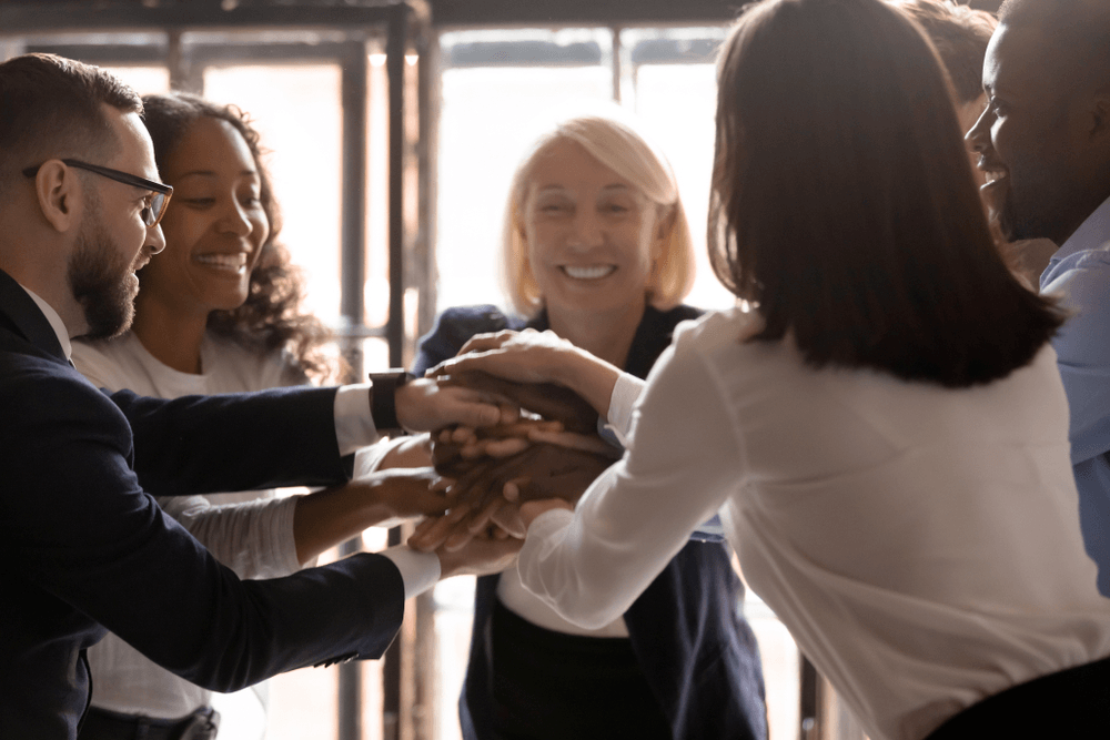 Employees putting hands together 