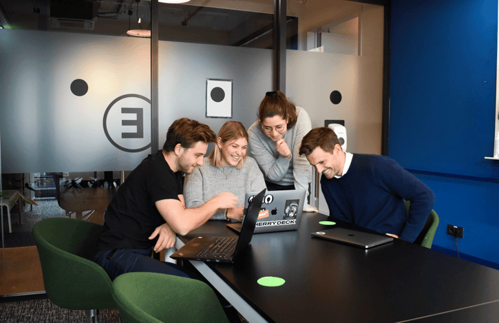 Collega's kijken samen naar scherm en lachen