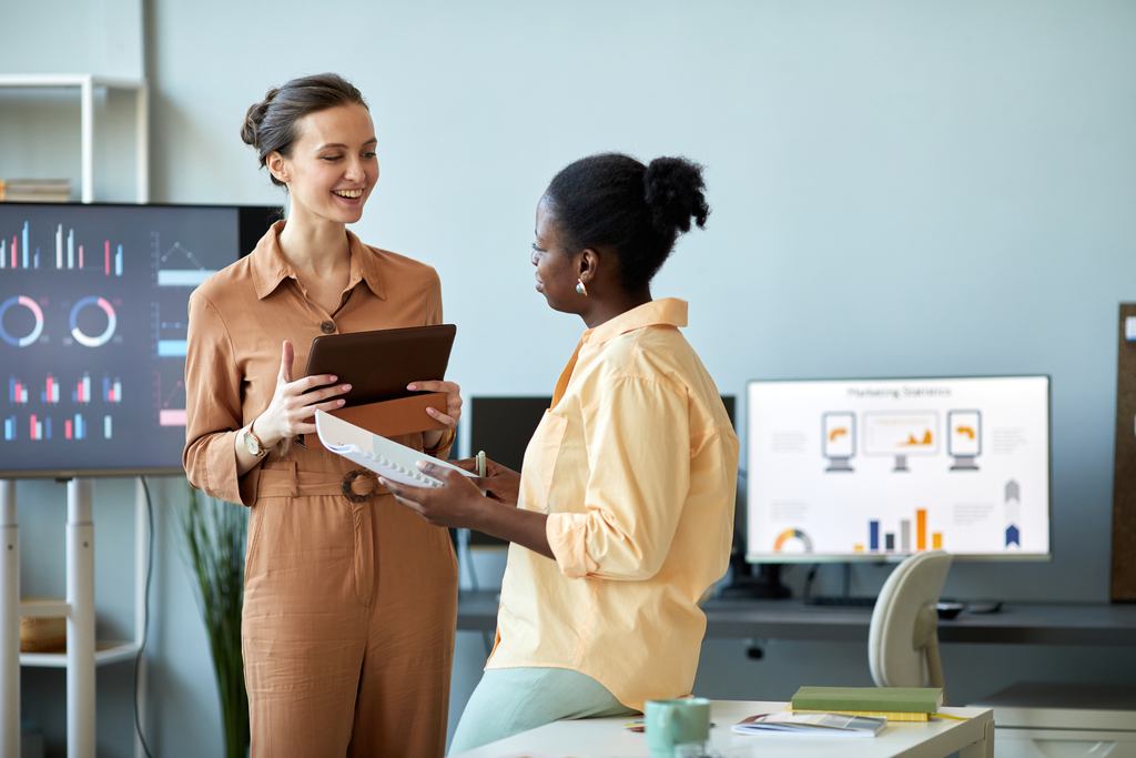 young successful coach with tablet looking at African American client