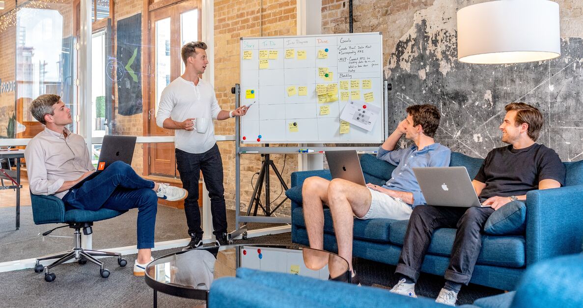 Male employees in a meeting room discussing project on white board