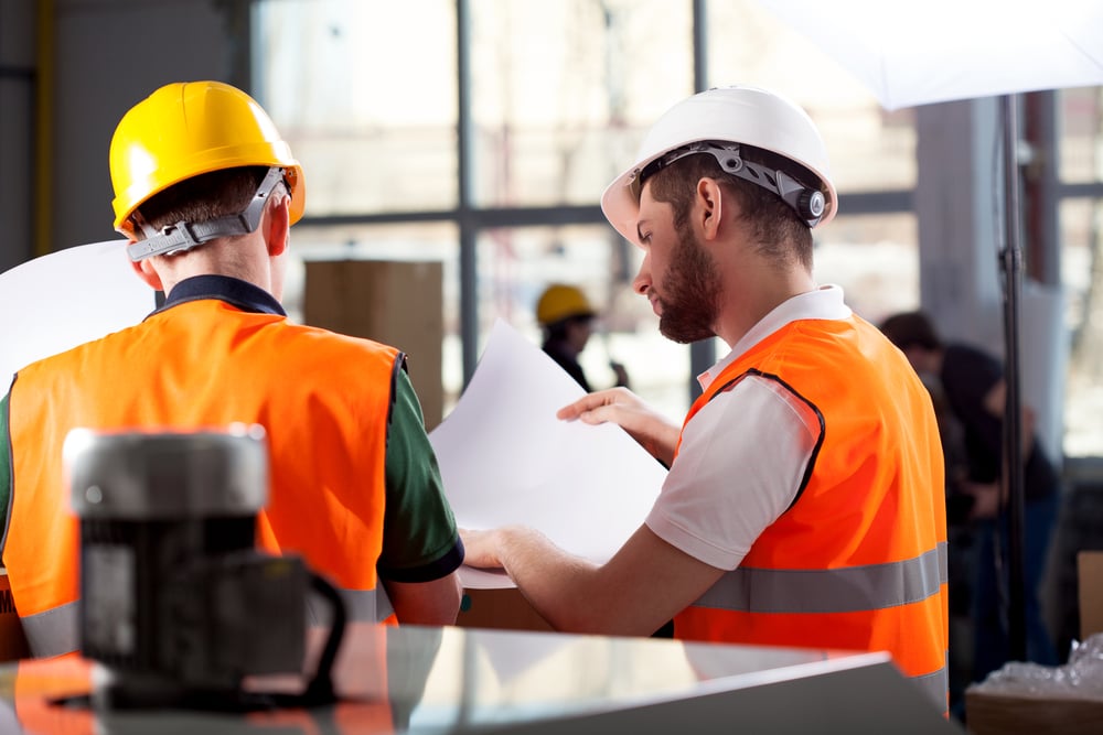 El trabajador y supervisor masculino de la fábrica están analizando planes