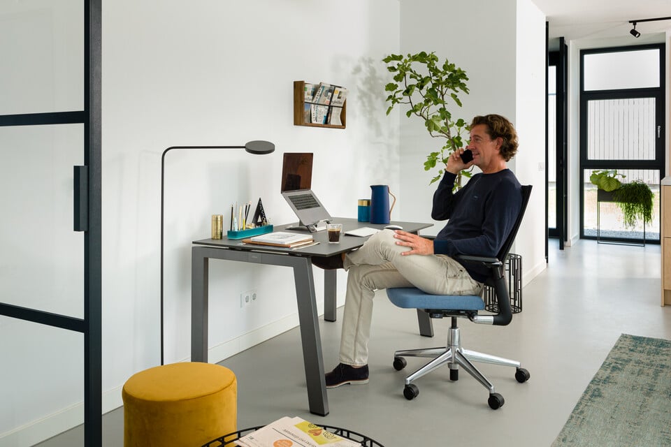 Man working at home sitting at desk on a phone call