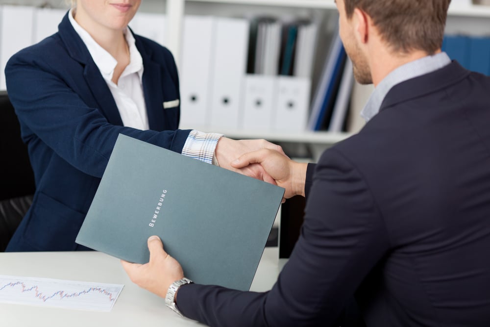 Midsection of a businessman shaking hands with a female interviewer in office-2