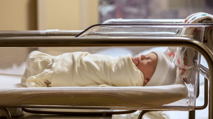 Newborn baby in hospital nursery symbolising neonatal leave
