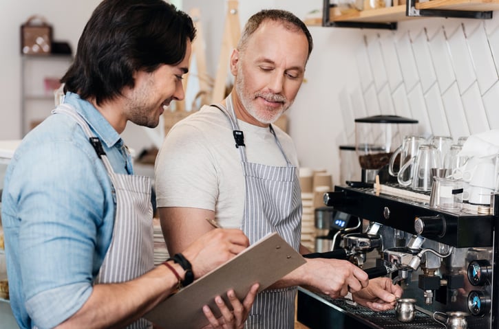 Our workplace. Smiling and content two male barista at work