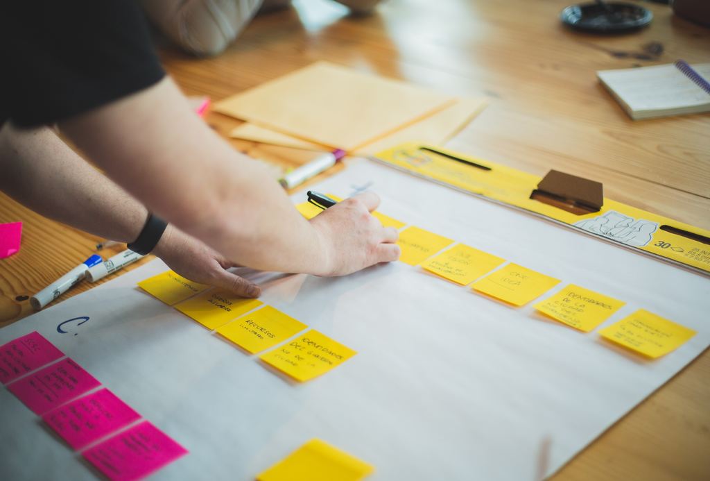 People working on a project using a clipboard and sticky notes