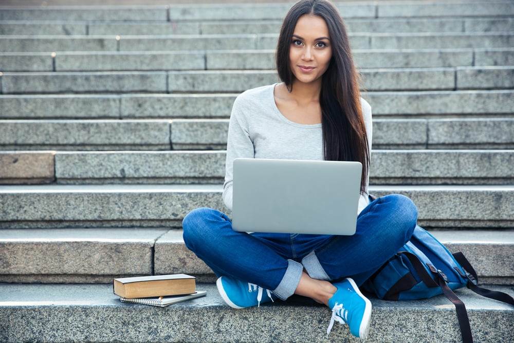 Jonge vrouw werkt op laptop op stadstrappen – vaardigheden ontwikkelen