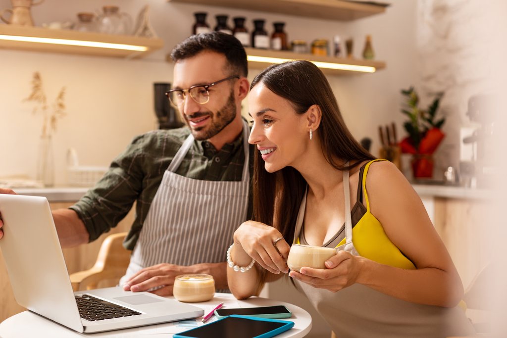 Restaurante de gerentes de cafeterías mirando la planificación o el horario en una computadora portátil