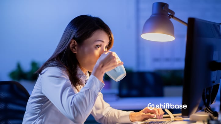 Werknemer drinkt koffie om wakker te blijven omdat ze verplicht moet overwerken