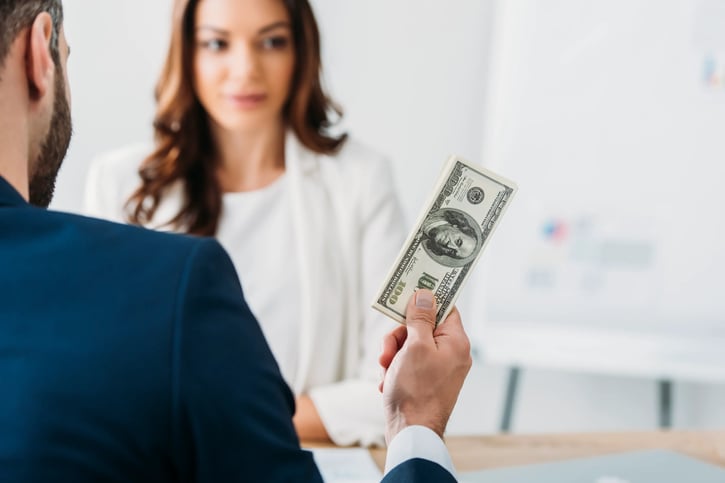 Selective focus of manager holding dolar symbolising employee salary or bonus pay
