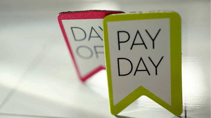 Shot of calendar highlighting pay day and day off tags symbolising vacation pay