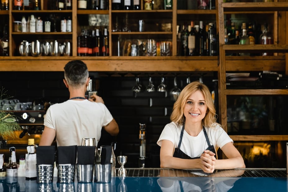 Smiling bar manager behind the bar counter, how to run a bar