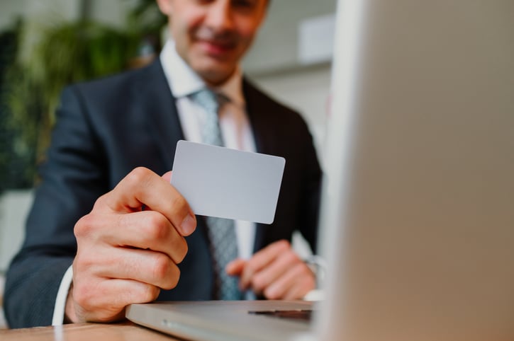Smiling business man holding payroll card after receiving their wages