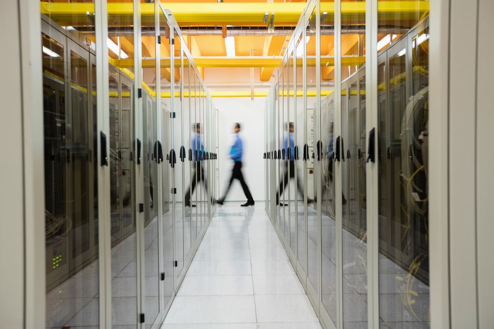 Technician walking in hallway of server room-2