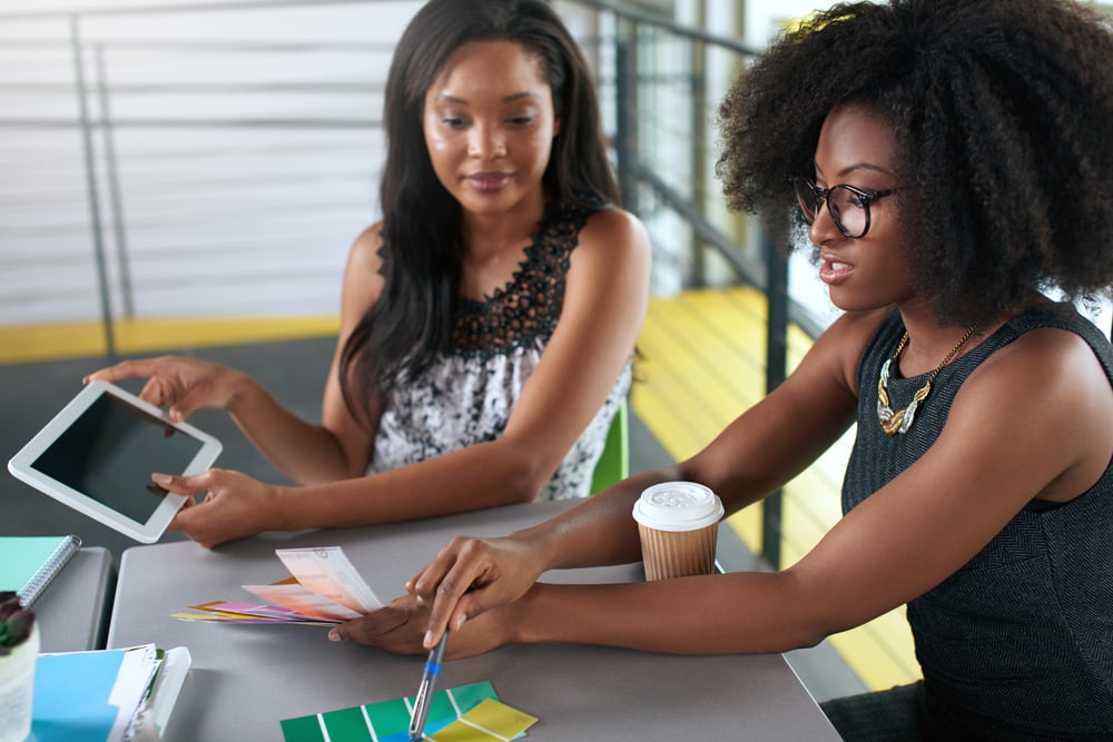 Zwei Kollegen arbeiten zusammen im Jobsharing-Modell und koordinieren ihre Arbeitszeit flexibel, um Aufgaben effizient zu erledigen.