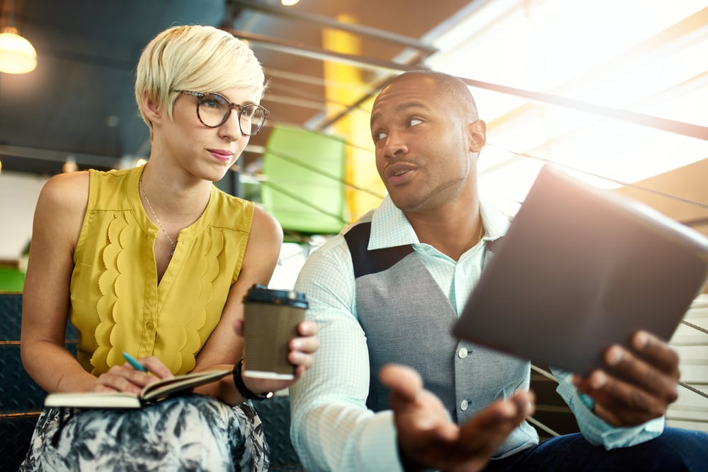 Two creative millenial small business owners working on social media strategy using a digital tablet while sitting in staircase-Oct-23-2023-12-01-56-9249-PM