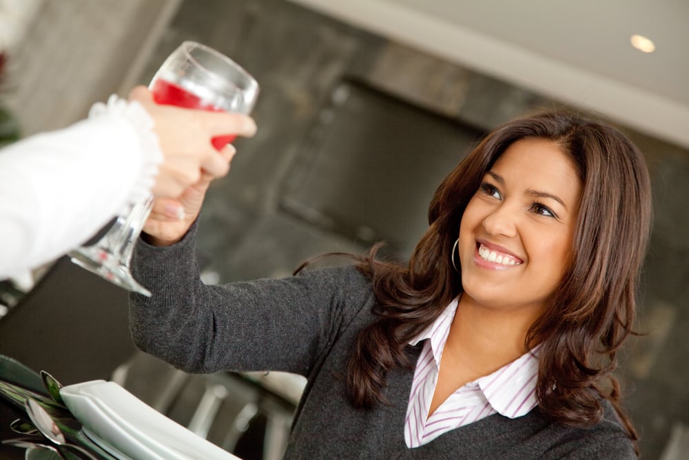 Woman toasting at a business lunch and smiling